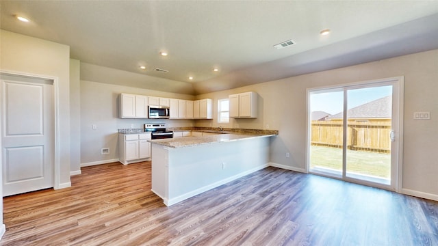 kitchen featuring kitchen peninsula, white cabinets, appliances with stainless steel finishes, and light wood-type flooring