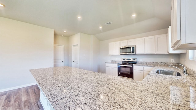 kitchen featuring light hardwood / wood-style floors, sink, light stone counters, stainless steel appliances, and white cabinetry