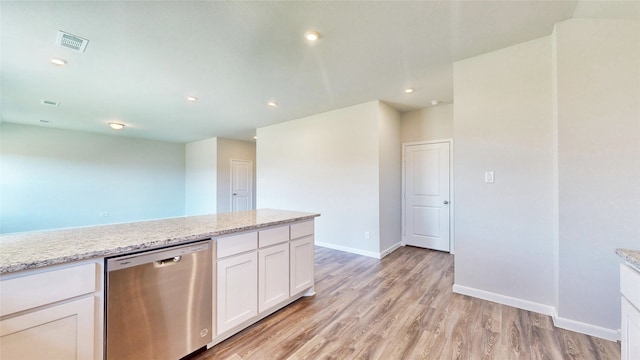 kitchen with light stone countertops, light wood-type flooring, white cabinetry, and stainless steel dishwasher