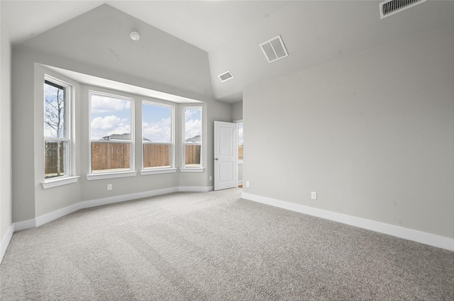 carpeted spare room with lofted ceiling