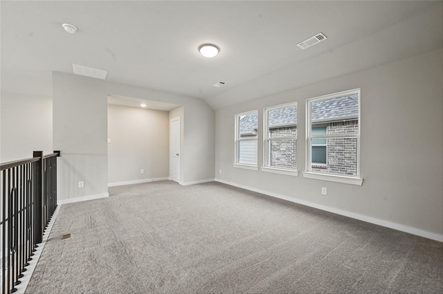 spare room featuring lofted ceiling and carpet floors