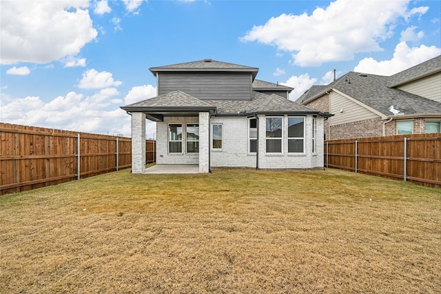 rear view of house featuring a yard and a patio area