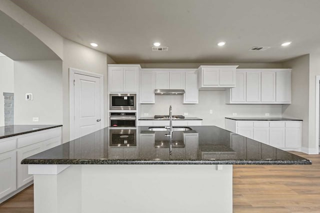 kitchen with white cabinetry, dark stone counters, and appliances with stainless steel finishes