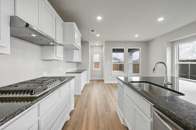 kitchen featuring extractor fan, white cabinetry, sink, dark stone countertops, and stainless steel appliances