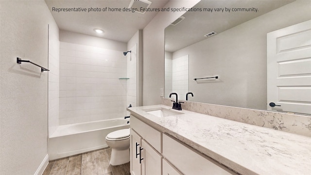 full bathroom with tiled shower / bath, toilet, hardwood / wood-style flooring, and large vanity