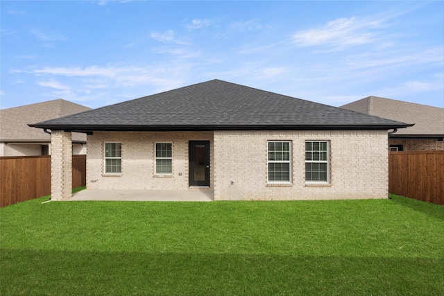 back of house with a lawn and a patio