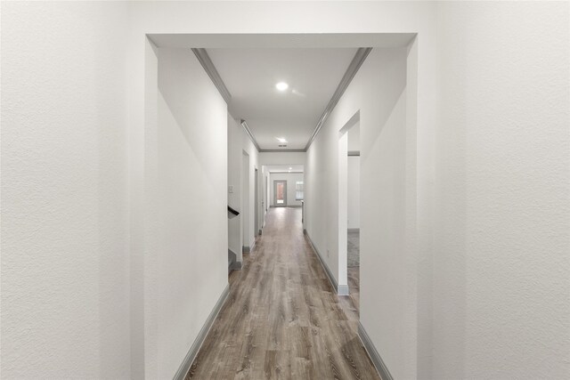 corridor featuring light hardwood / wood-style flooring and ornamental molding