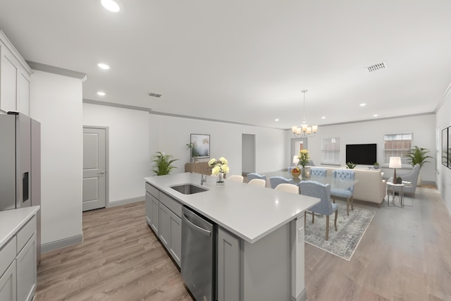 kitchen with a center island with sink, an inviting chandelier, stainless steel appliances, and light hardwood / wood-style floors