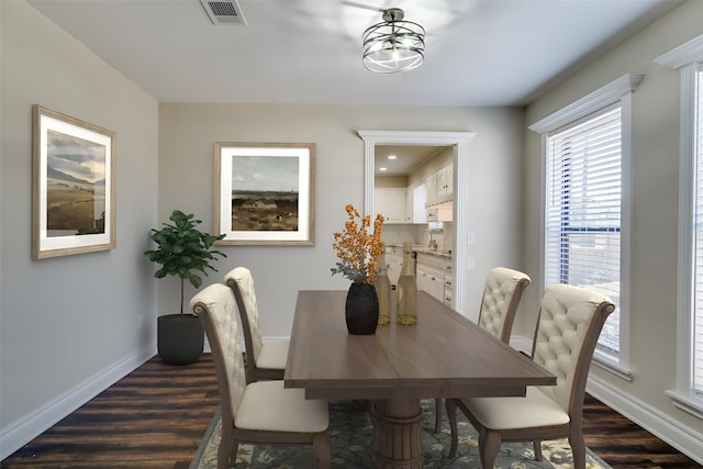 dining space featuring a notable chandelier and dark wood-type flooring