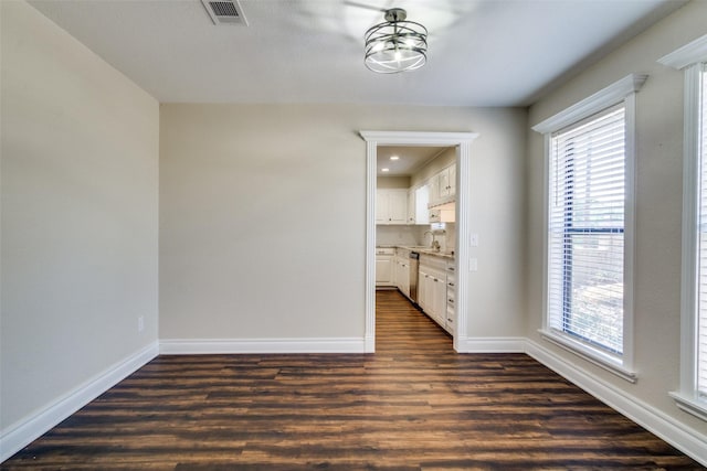 unfurnished dining area with dark hardwood / wood-style flooring and an inviting chandelier