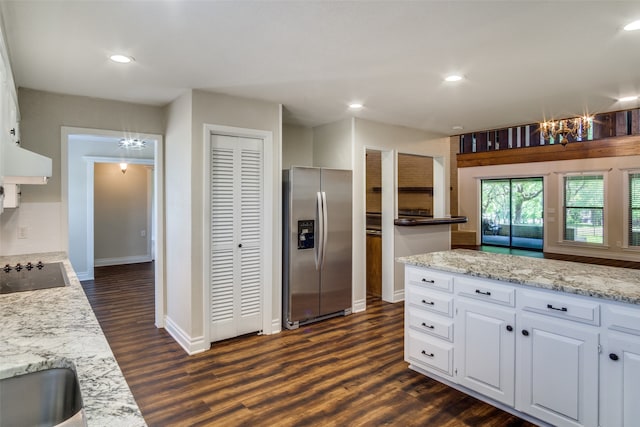 kitchen with white cabinets, decorative backsplash, stainless steel fridge, and black electric stovetop