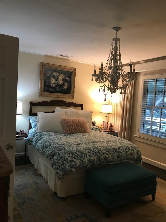 bedroom featuring crown molding and an inviting chandelier