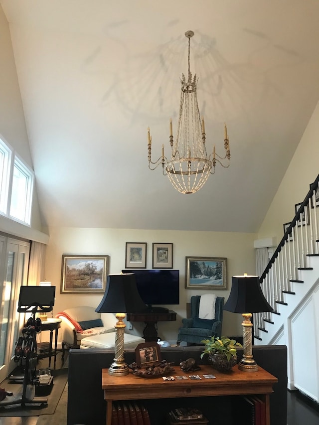 living room featuring high vaulted ceiling and a notable chandelier