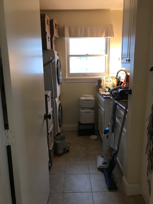 washroom featuring light tile patterned floors and stacked washer / drying machine