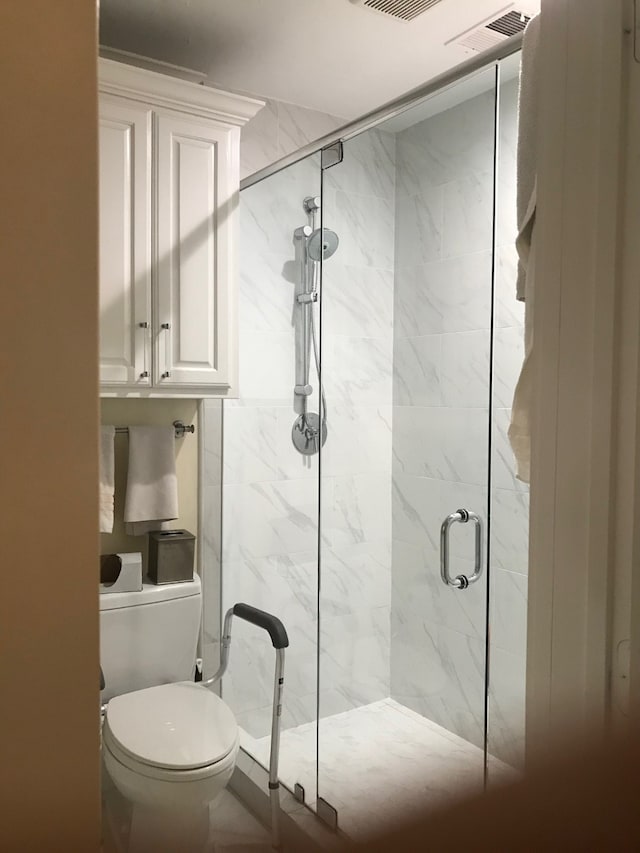 bathroom with toilet and an enclosed shower