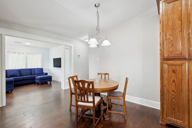 dining area with dark wood-type flooring and a notable chandelier