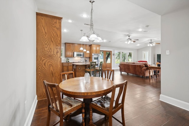 dining space featuring dark hardwood / wood-style floors and ceiling fan with notable chandelier