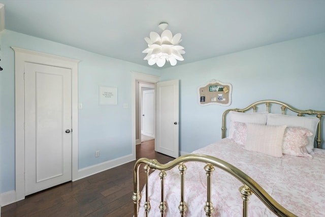 bedroom with dark wood-type flooring and a chandelier