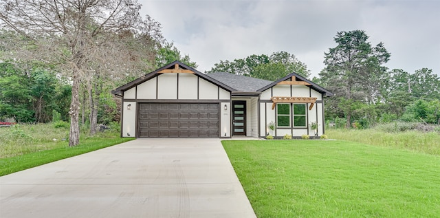 tudor home featuring a garage and a front yard