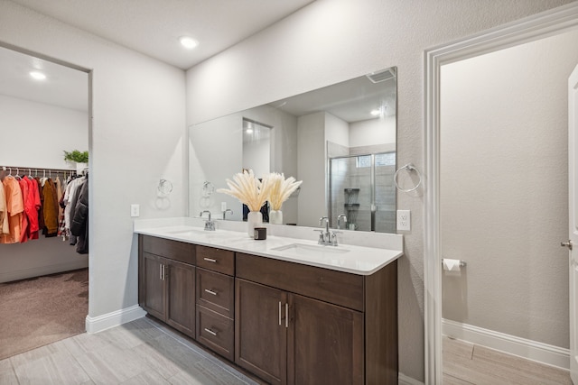 bathroom featuring walk in shower and vanity