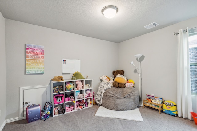 recreation room with a textured ceiling and carpet flooring