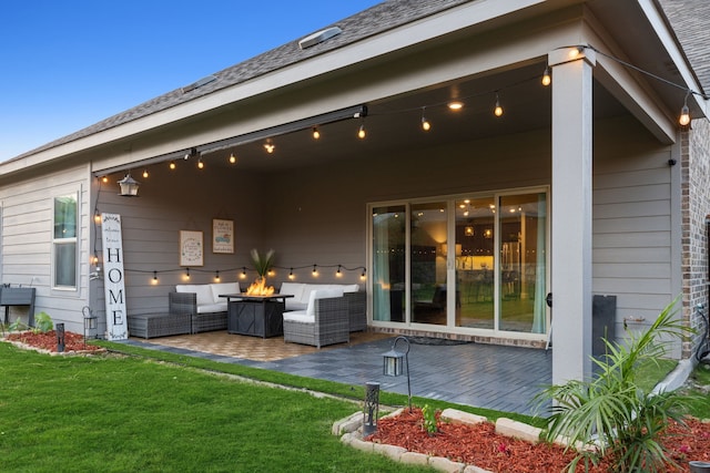 rear view of house with an outdoor living space with a fire pit, a yard, and a patio