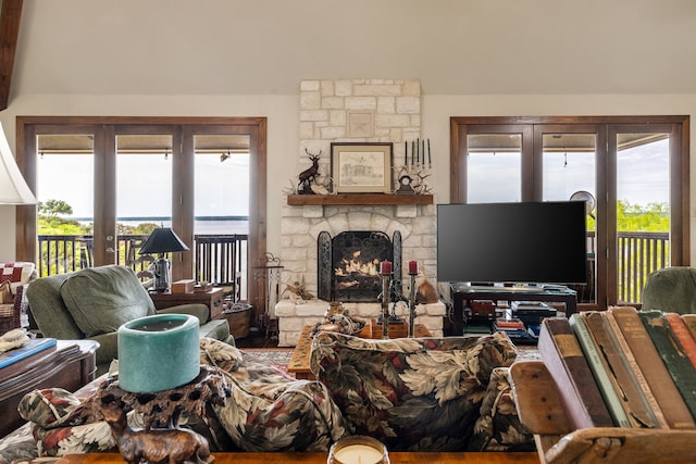 living room featuring a stone fireplace and french doors