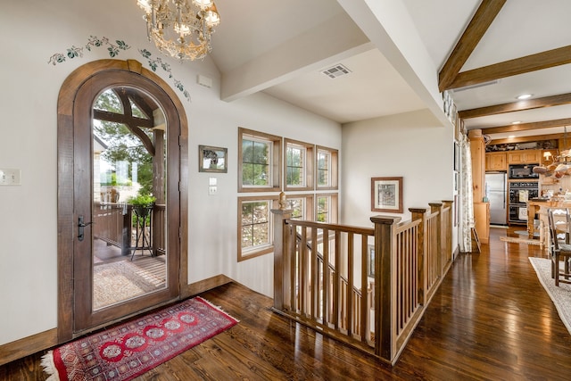 entryway with beamed ceiling, dark hardwood / wood-style flooring, and an inviting chandelier