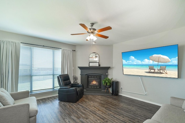 living room featuring ceiling fan and dark wood-type flooring