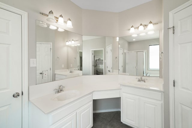 bathroom featuring tile patterned floors, a shower with door, and vanity