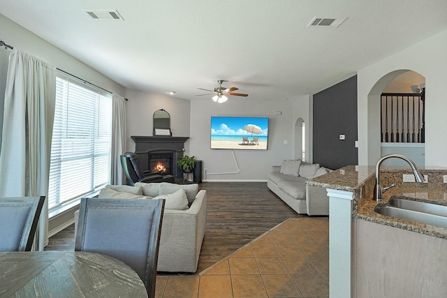 tiled living room featuring ceiling fan and sink