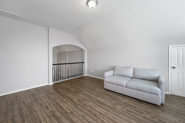 unfurnished room with lofted ceiling and dark wood-type flooring