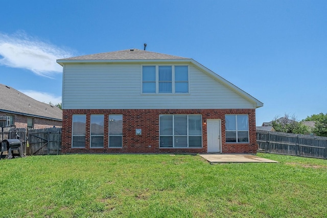 rear view of house with a lawn and a patio area