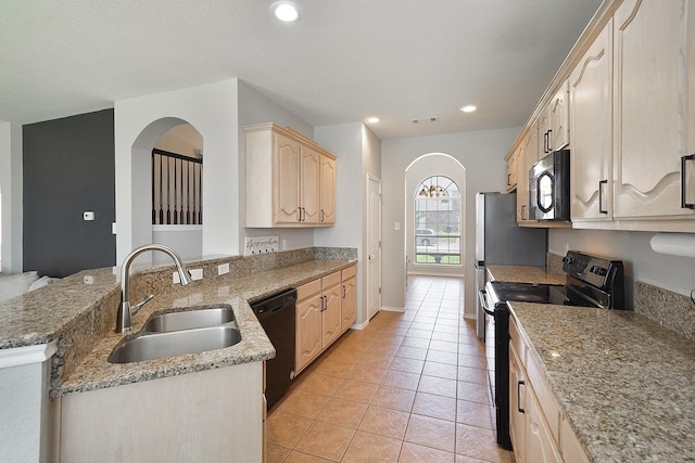 kitchen with light stone counters, sink, black appliances, light brown cabinets, and light tile patterned flooring