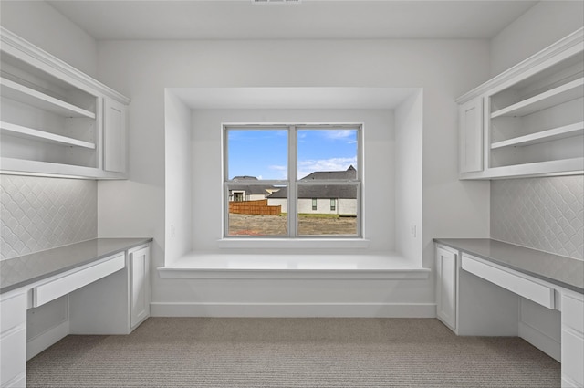 unfurnished office featuring light carpet and built in desk