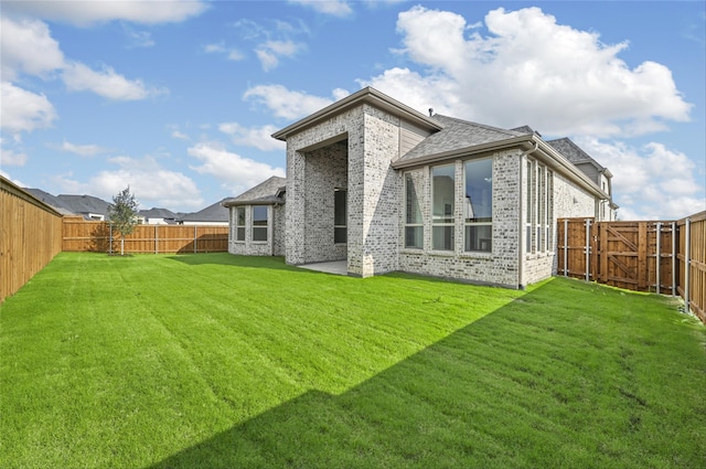 rear view of house with a patio and a lawn