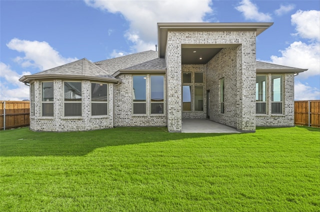 rear view of property with a yard and a patio area