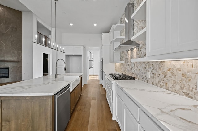 kitchen featuring white cabinets, a large island with sink, and hanging light fixtures