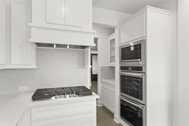 kitchen with appliances with stainless steel finishes, tasteful backsplash, white cabinets, and dark hardwood / wood-style floors