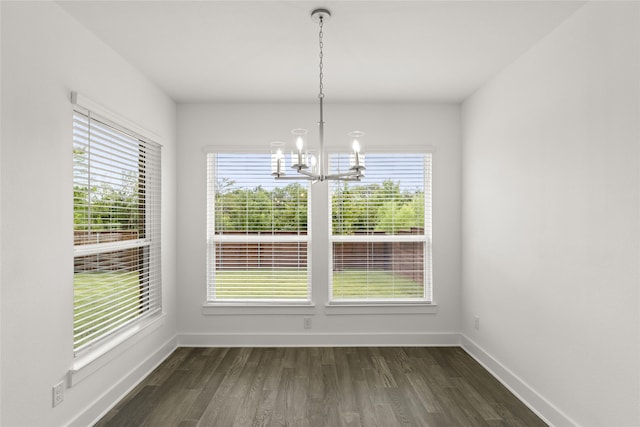 unfurnished dining area with dark hardwood / wood-style floors and an inviting chandelier