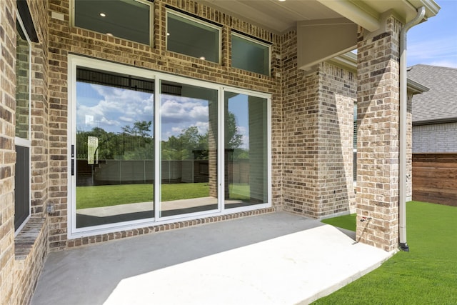 property entrance with a patio area and a lawn