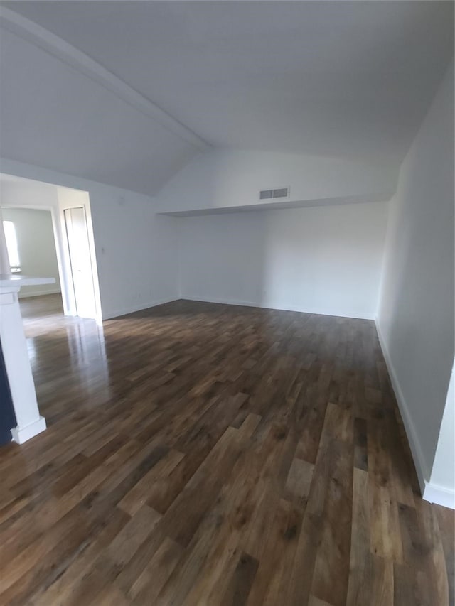 unfurnished room featuring dark hardwood / wood-style floors and vaulted ceiling