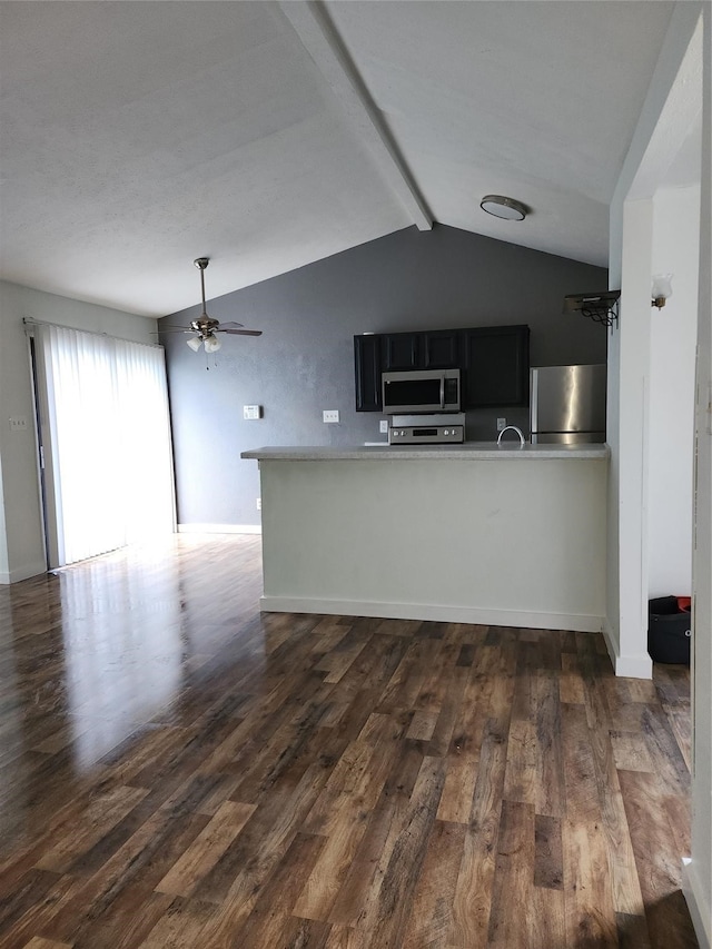 kitchen with lofted ceiling with beams, dark wood-type flooring, ceiling fan, and fridge