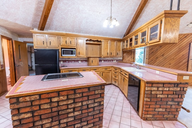 kitchen with a center island, vaulted ceiling with beams, black appliances, and tile countertops