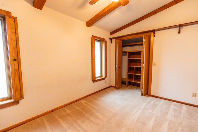 unfurnished bedroom featuring carpet flooring, vaulted ceiling with beams, and ceiling fan