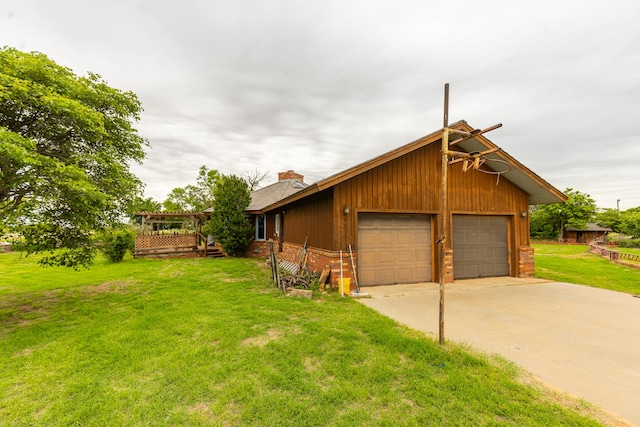 exterior space featuring a garage, a lawn, and a wooden deck