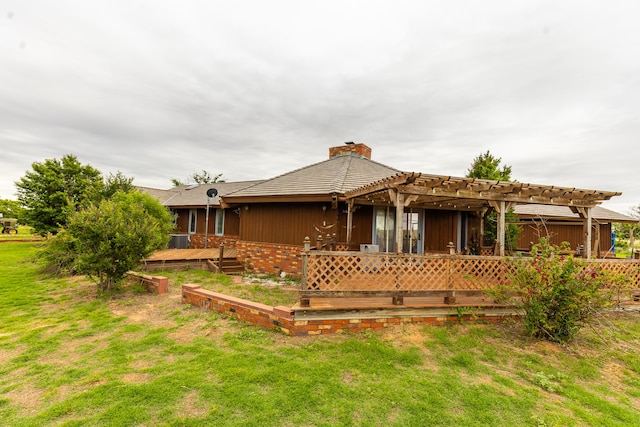 back of property featuring a pergola, a deck, and a yard