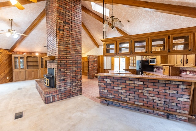 interior space with ceiling fan, beamed ceiling, black refrigerator, light colored carpet, and high vaulted ceiling