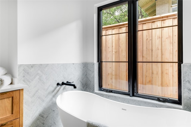 bathroom with tile walls and a tub to relax in