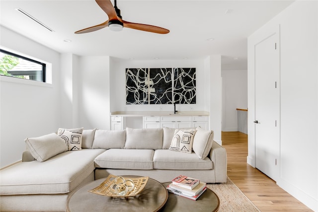 living room with light wood-type flooring and ceiling fan